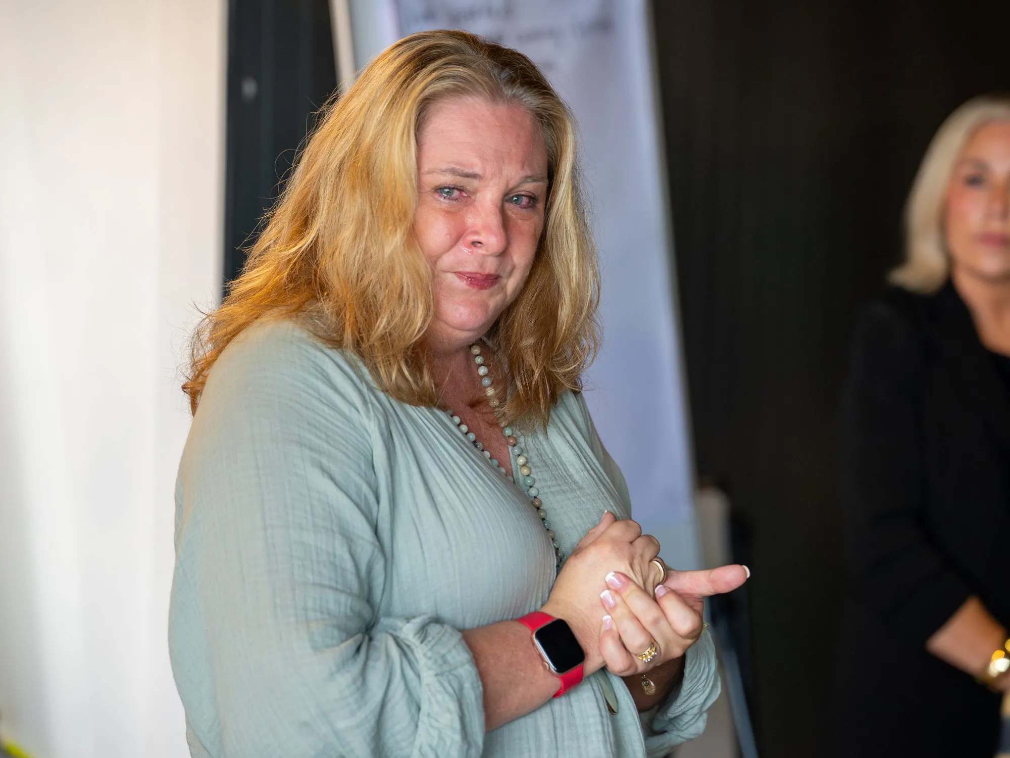 A participant visibly moved, hands clasped, during a quiet moment