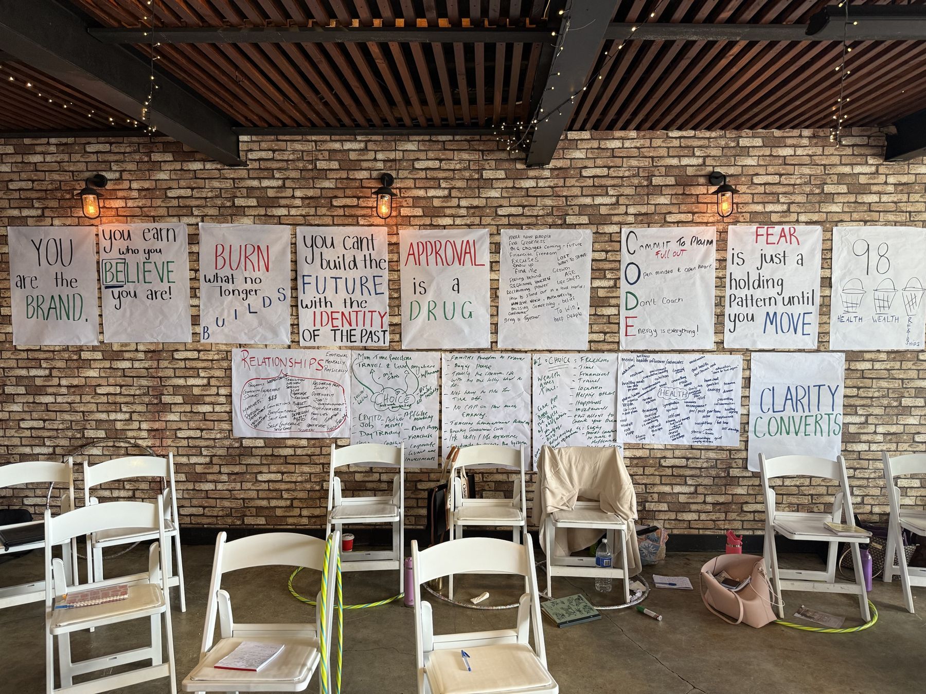 A workshop room with handwritten posters covering a brick wall
