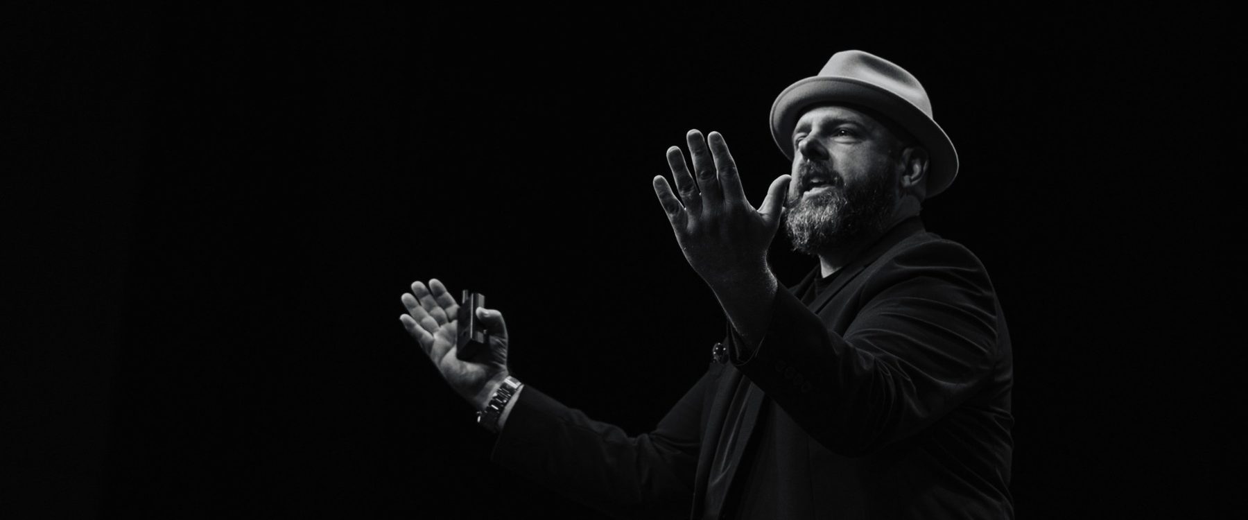 Brett Davis on stage in black and white