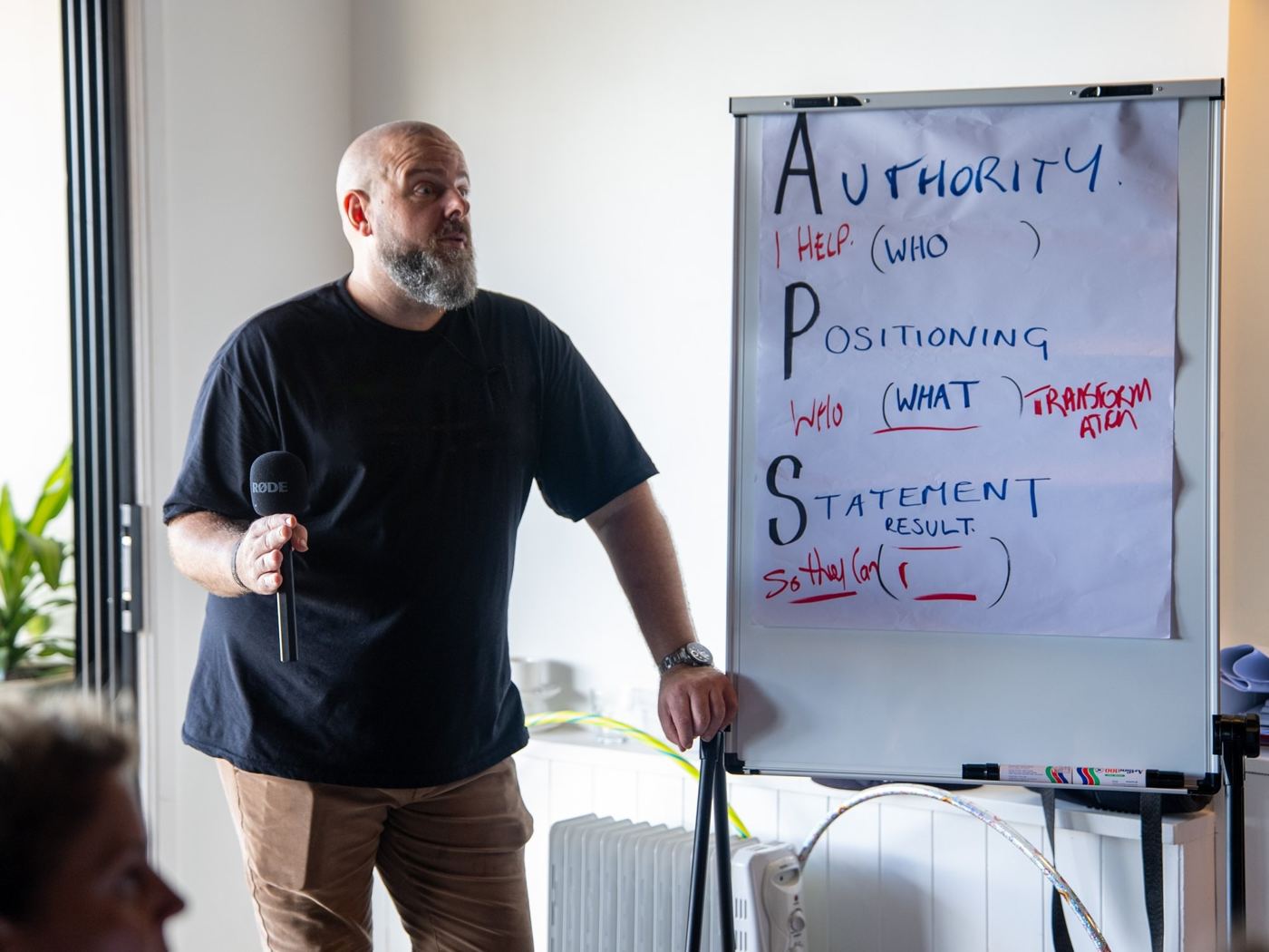 Brett Davis coaching a small group beside a handwritten flipchart